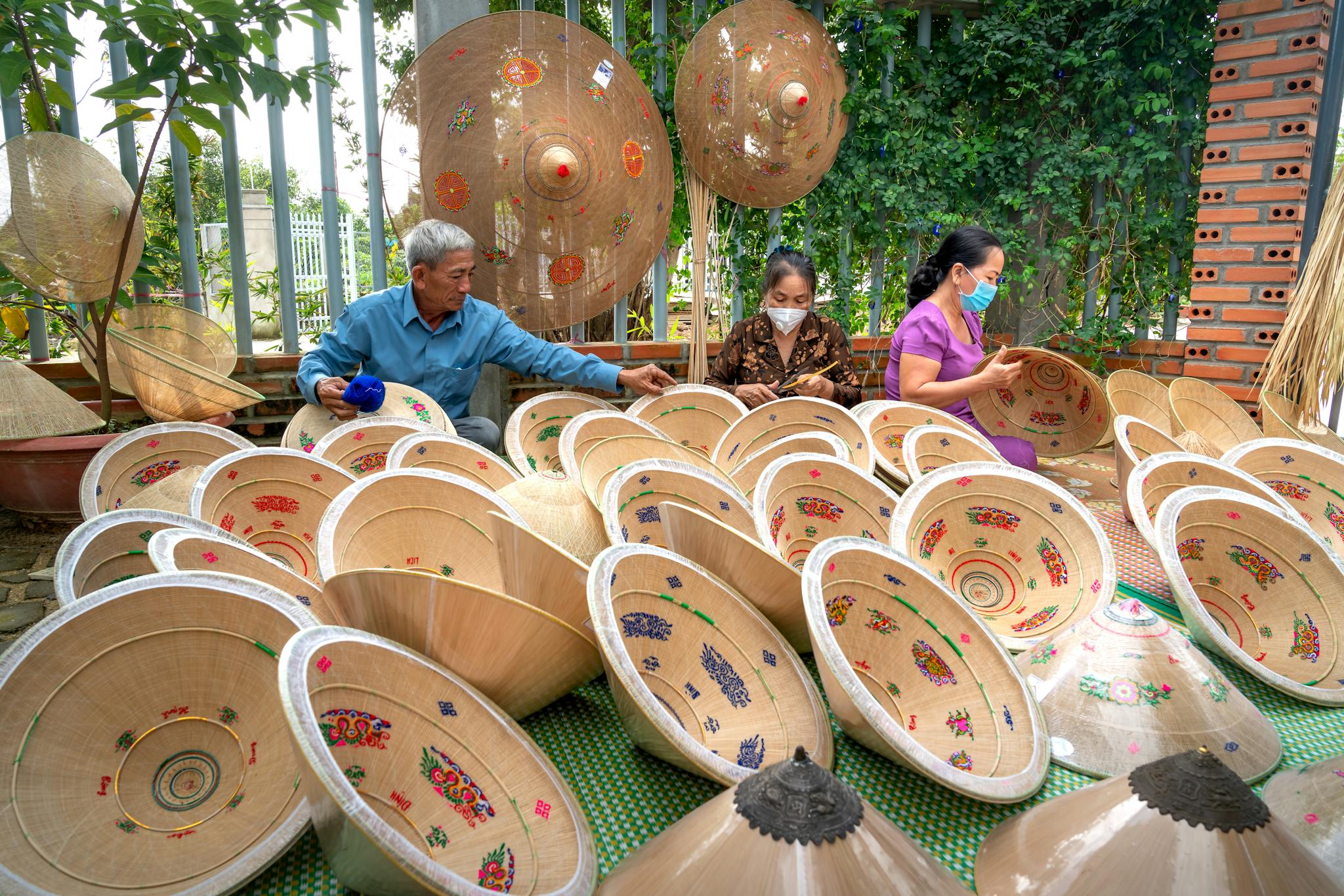 artisans creating decorative conical hats in an