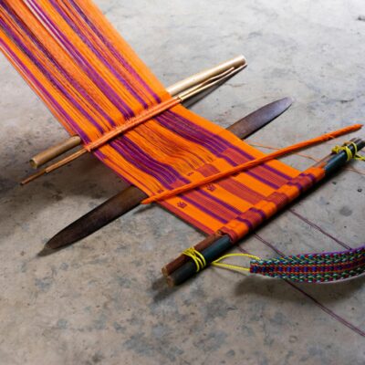 Colorful Mexican textile on a traditional floor loom in Pantelhó, Mexico.