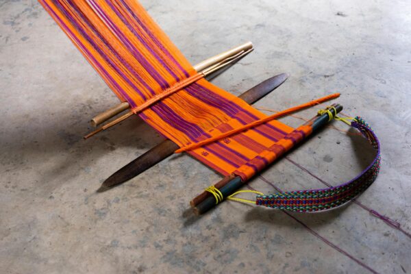 Colorful Mexican textile on a traditional floor loom in Pantelhó, Mexico.