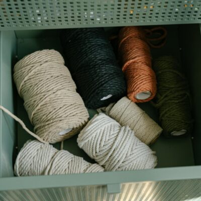 Top view of various yarn rolls stored in a metal drawer, perfect for textile crafts and embroidery projects.