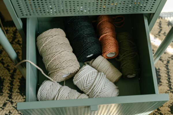 Top view of various yarn rolls stored in a metal drawer, perfect for textile crafts and embroidery projects.